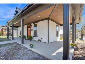 Inviting covered front porch featuring decorative plants and a vibrant orange front door at 602 Gray Ave, Durham, NC 27701