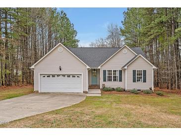 Charming single-Gathering home with attached garage and well-manicured lawn and tall trees at 100 Hillside Village Dr, Louisburg, NC 27549