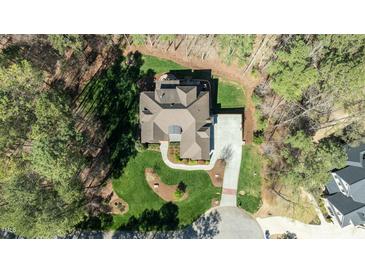 Stunning aerial view of a landscaped home featuring a circular driveway and back patio with a cozy fire pit at 1009 High Trail Ct, Wake Forest, NC 27587