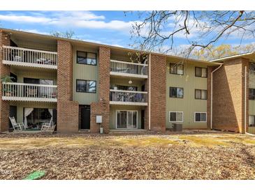 Apartment building with brick accents, multiple balconies, and a well-maintained yard with fallen leaves at 1283 Schaub Dr # B, Raleigh, NC 27606