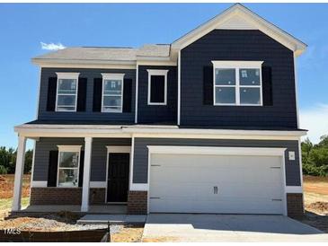 Two-story home featuring a large garage, dark siding, white trim, and black shutters against a blue sky at 144 E Victory View Ter # 66, Smithfield, NC 27577