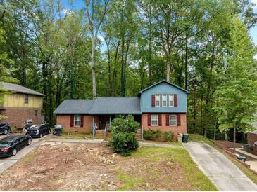 Charming home featuring a brick facade, complemented by well-maintained landscaping and a serene wooded backdrop at 1505 Harth Dr, Garner, NC 27529