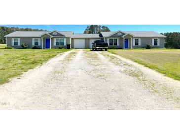 Charming duplex featuring a long driveway, well-manicured lawn and matching blue doors at 20 Chaney Ln, Louisburg, NC 27549