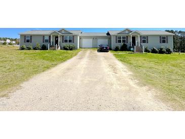 Exterior view of charming duplex homes with gravel driveway and manicured lawn, evoking curb appeal at 30 Chaney Ln, Louisburg, NC 27549