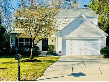 Charming two-story home with attached garage, landscaped yard and a fresh green lawn at 3316 Perkins Ridge Rd, Raleigh, NC 27610