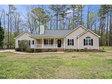 Charming single-story home with a welcoming front porch, complemented by a well-maintained yard and mature trees at 340 Castleberry Rd, Clayton, NC 27527
