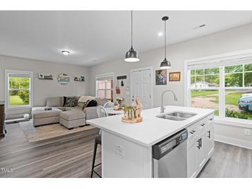 Open-concept living room and kitchen with modern island, stainless steel appliances, and stylish decor at 501 E Granville St, Dunn, NC 28334
