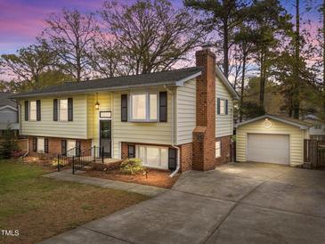 Charming exterior of a two-story home featuring a brick chimney and attached garage with large driveway at 6216 Lewisand Cir, Raleigh, NC 27615
