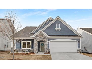 Charming single Gathering home with stone accents, blue siding, and a welcoming two car garage at 63 Mable Court # 6, Lillington, NC 27546