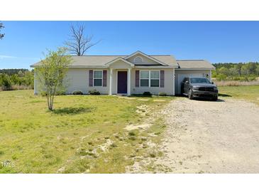 Charming single-story home featuring a gravel driveway and a well-maintained front lawn at 65 Chaney Ln, Louisburg, NC 27549