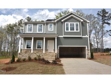A modern two-story home featuring a two-car garage, stone accents, and gray siding at 70 Cordoba Dr, Franklinton, NC 27525