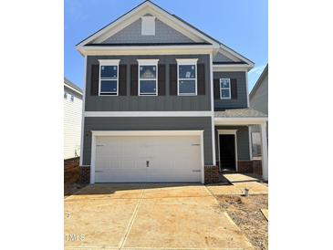 New two-story home featuring a gray exterior, white trim, and a two-car garage at 76 Commons Cir, Clayton, NC 27520