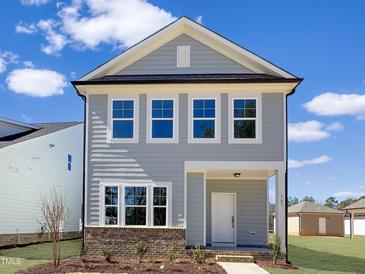 Charming two-story home featuring gray siding, white trim, and a welcoming front entrance and landscaped yard at 765 Portland Rose Dr, Knightdale, NC 27545