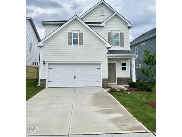 Charming two-story home featuring a spacious two-car garage and manicured lawn at 84 Commons Cir, Clayton, NC 27520