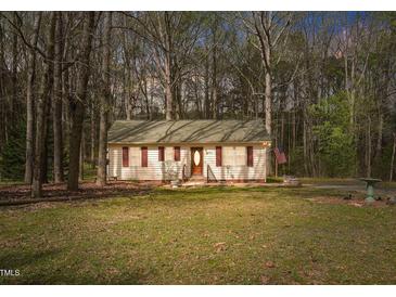 Charming single-story home with a well-manicured lawn and mature trees creating a serene setting at 900 Cricket Knoll Rd, Fuquay Varina, NC 27526
