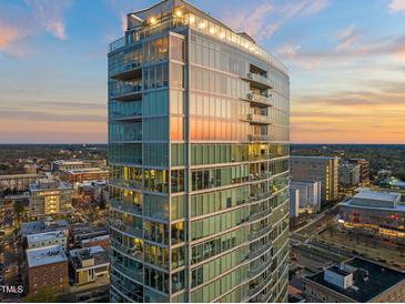 Stunning glass high-rise exterior reflecting the sunset, showcasing its modern design and city views at 110 N Corcoran St # 2302, Durham, NC 27701