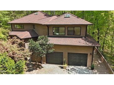 Stunning two-story house with a two-car garage and beautiful wood exterior nestled in a lush forest setting at 111 Standing Rock Rd, Chapel Hill, NC 27516