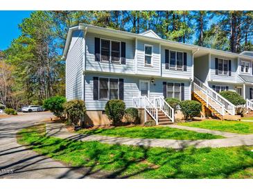 Inviting townhome with manicured lawn, mature trees, and a classic light blue color scheme at 121 Westview Dr # 43, Carrboro, NC 27510