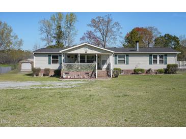 Charming single-story home featuring a cozy porch and well-maintained front yard and a detached shed at 122 Blueberry Dr, Selma, NC 27576