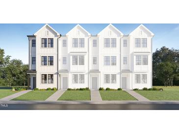 Charming exterior of a newly constructed townhome features white siding and black framed windows at 1546 Crescent Townes Way, Raleigh, NC 27604