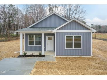 Charming single-story home featuring a light gray exterior and well-manicured front lawn with an inviting front porch at 175 David Ln, Roxboro, NC 27573