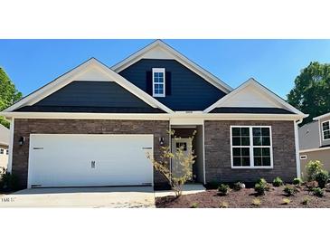 Charming single-Gathering home featuring stone and blue siding, a two-car garage, and a well-manicured lawn at 1914 Malvina Ct, Graham, NC 27253