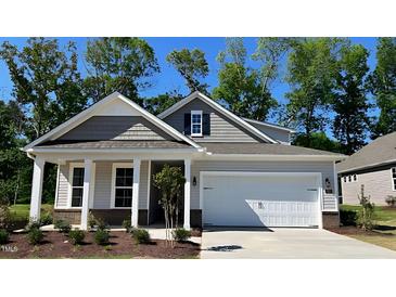 Charming one-story home with a covered front porch, attached garage, and beautiful architectural details at 1917 Malvina Ct, Graham, NC 27253