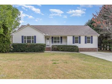 Charming single-story home featuring blue shutters, a manicured lawn, and a welcoming front porch at 201 Alice Dr, Garner, NC 27529