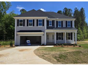 Charming two-story home featuring black shutters, an open garage, and a well manicured lawn at 25 Bold Dr, Youngsville, NC 27596