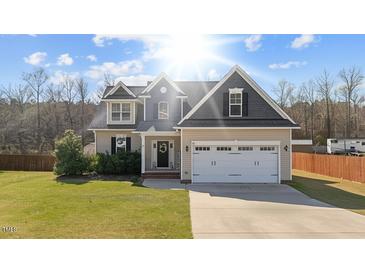 Charming two-story home with a well-manicured lawn and an attached two-car garage at 36 Deep Woods Ln, Cameron, NC 28326