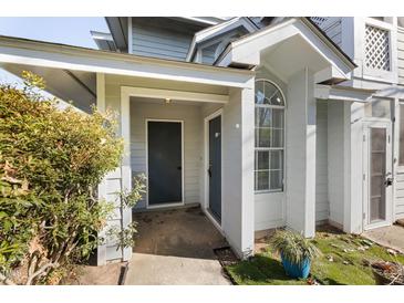 Charming home entrance featuring a covered porch, gray door, and a window with decorative trim at 4911 Hollenden Dr # 208, Raleigh, NC 27616