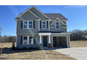 Charming two-story home featuring gray siding and a convenient attached one-car garage at 74 Harvest Hills Ln, Dunn, NC 28334