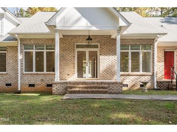 Charming brick home featuring a covered front entrance with classic columns and ample natural light at 1021 Reaves Dr Dr, Chapel Hill, NC 27516