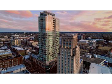 Stunning aerial view of city high rise with modern architectural design and reflective glass exterior at dusk at 110 N Corcoran St # 2502, Durham, NC 27701