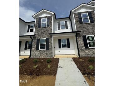 New townhome featuring stone accents, black shutters, and a welcoming entrance in a well-lit neighborhood at 1102 Brookrun Dr, Oxford, NC 27565