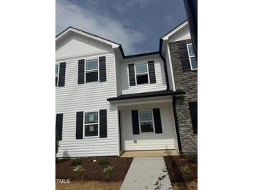 New two-story townhome with white siding, black shutters, and stone accents on the exterior at 1104 Brookrun Dr, Oxford, NC 27565