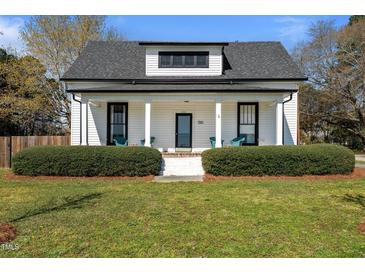 Charming home featuring a cozy front porch with decorative shrubs and inviting curb appeal at 1310 S 8Th St, Lillington, NC 27546