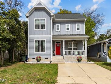 Charming two-story home with a welcoming front porch, red door, and landscaped front yard at 1515 E Jones St, Raleigh, NC 27610