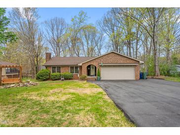 Charming brick home with attached garage and well-maintained lawn and paved driveway at 1525 Rogers Rd, Graham, NC 27253