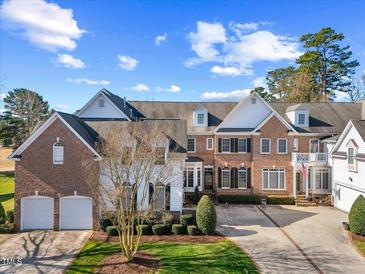 Spacious brick home with two-car garage, manicured lawn, and classic American flag display at 2308 Carriage Oaks Dr, Raleigh, NC 27614