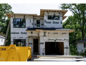 New construction home exterior featuring the garage door and protective wrap before the exterior finish is applied at 2603 Vineyard St, Durham, NC 27707