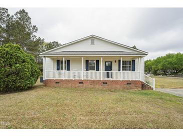 Charming single-story home with a welcoming front porch, white siding, and blue shutters at 327F Bobbitt Rd, Clayton, NC 27520
