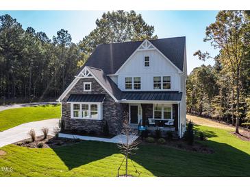 Beautiful two-story home with a stone and white facade and well-manicured lawn at 581 Magnolia Acres Ln, Fuquay Varina, NC 27526