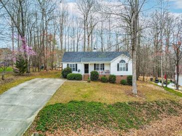 Charming one-story home with a well-manicured lawn, inviting front porch and long driveway at 6208 Silver Spring Ct, Willow Springs, NC 27592