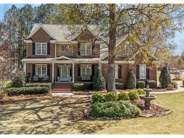 Beautiful two-story brick home with mature landscaping and a charming front yard fountain at 749 Hadrian Dr, Garner, NC 27529