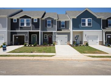 Row of new two-story townhomes with driveways, lawns, and varied siding and door colors at 1169 Abbott St, Mebane, NC 27302