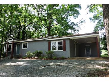 Charming brick home featuring a carport, fresh landscaping, and a welcoming entrance at 1212 St. Marys Rd, Hillsborough, NC 27278