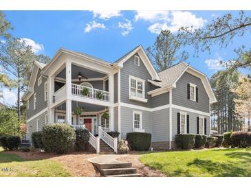 Charming two-story home with gray siding, white trim, covered porch and manicured landscaping at 1300 Marshall Farm St, Wake Forest, NC 27587
