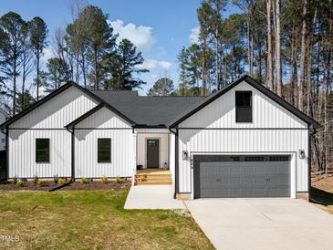 Charming new construction home featuring white siding, a gray roof, and an attached two-car garage at 1429 Sagamore Dr, Louisburg, NC 27549