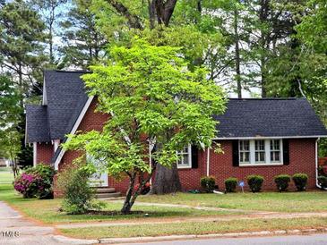 Charming brick home with a well-manicured lawn and mature trees at 1522 W Thomas St, Rocky Mount, NC 27804